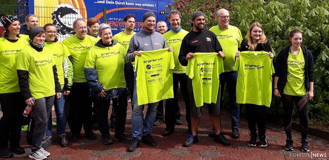 Bürgermeister Manfred Weber (3.v.r) und Sponsor Andreas Grübel (Bildmitte, 6.v.r.) präsentieren zusammen mit einigen Teilnehmern das Laufshirt zum