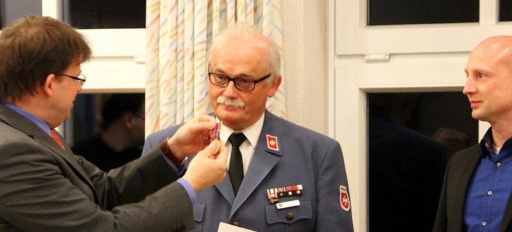 Erster Kreisbeigeordneter Heiko Wingenfeld (links) und Fachdienstleiter Gefahrenabwehr des Landkreis Fulda Frank Reith (rechts) überreichen Winfried Bug (Mitte) die Goldene Verdienstmedaille des Landes Hessen im Katastrophenschutz für 40 Jahre aktiven Dienst.