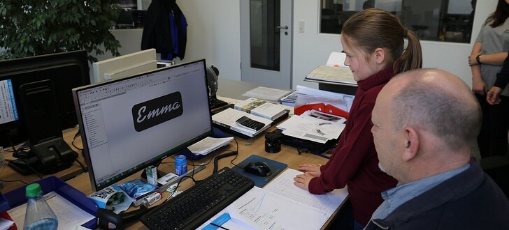 Emma Weitz entwirft gemeinsam mit dem Leiter des Konstruktionsbüros, Klaus Bub, ein Namensschild.