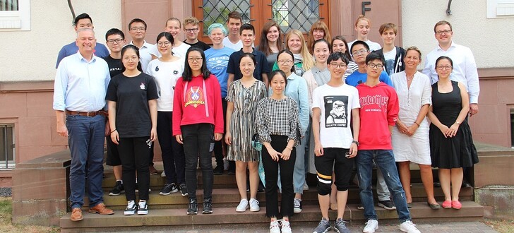 Empfang im Landratsamt Fulda: Die deutsch-chinesische Schülergruppe mit Landrat Bernd Woide (links), Erstem Kreisbeigeordneten Frederik Schmitt (dritte Reihe rechts), den Hünfelder Lehrerinnen Qian Neumann-Wang und Sabine Mielke (zweite Reihe rechts und Zweite von rechts) sowie den Pädagogen aus Liyang Wu Xue Mei (Vierte von links) und Cheng Peng (zweite Reihe Dritter von rechts).