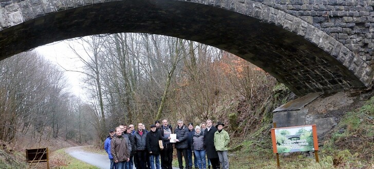 „Helft uns, unsere Historische Brücke zu erhalten“ steht auf dem Schild – genau das tat Landrat Görig mit dem Überreichen einer OVAG-Spende an den Vereinsvorsitzenden Gerd Köhler. Grebenhains Bürgermeister Sebastian Stang, Mitglieder des Vereins „Historische Brücke Hartmannshain“ und des Ortsbeirats setzen sich dafür ein, dass die Brücke noch in diesem Jahr saniert und mit einem „Brückenfest“ wieder eröffnet werden kann.