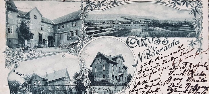 Die Postkarte zeigt einen Blick auf das damalige Niederaula, auf die Villa Eichmann (links unten), der Gastwirtschaft Grenzebach (links oben) und die Post in der Bildmitte.