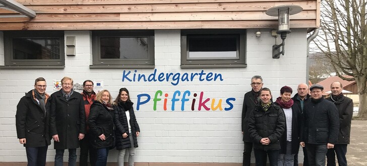 Bürgermeister Andre Stenda (links) und Kindergartenleiterin Nadine Köhler-Fey (5. v. l.) präsentieren den Mitgliedern des Bau- und Umweltausschusses den Sachstand der Sanierungs- und Modernisierungsarbeiten im Kindergarten „Pfiffikus“ in Ausbach.