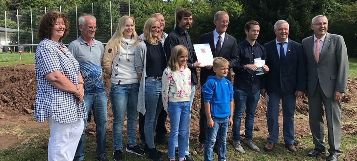 Staatsminister Wintermeyer (vierter von rechts) übergibt den Förderbescheid für den Bau des neuen Spielplatzes