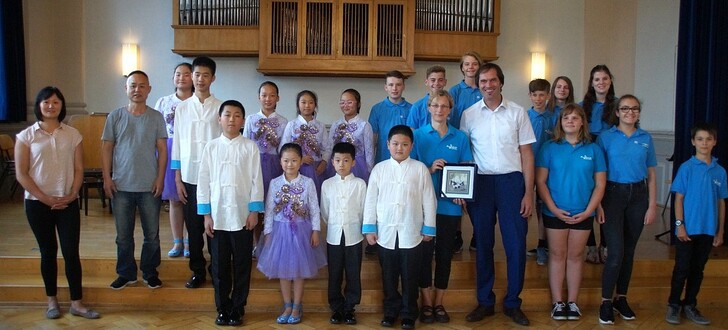 Das Ensemble "Blauer Flieder" und das Gitarrenjugendorchester der Musikschule mit Übersetzerin Yangwenjia Zhoe, Musikschulleite Wei Chen und die Musikschulleiter Sabine Schweiger und Timo Wichmann