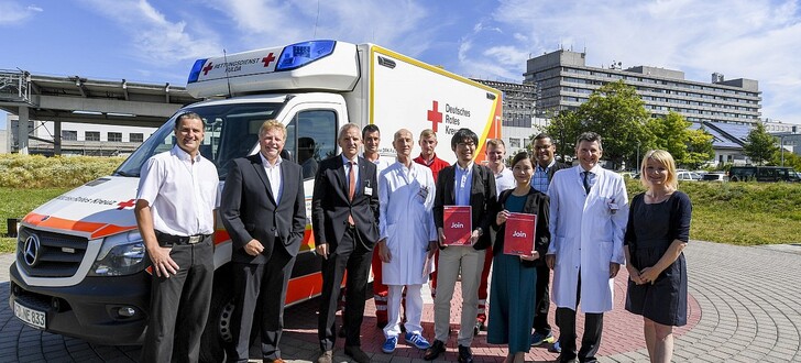 Obligatorisches Gruppenbild (v.li.): DRK-Wachenleiter Marko Hellmich,
DRK-Geschäftsführer Christoph Schwab, vom Klinikum Fulda: Priv.-Doz. Dr. Thomas Menzel (Vorstand) und Prof. Dr. C.-A. Greim, die Delegation aus Japan, Prof. Dr. Martin H. Hessmann (Klinikum Fulda) sowie Nicole Weider - im Hintergrund: das diensthabend Rettungsdienstpersonal des DRK Fulda.